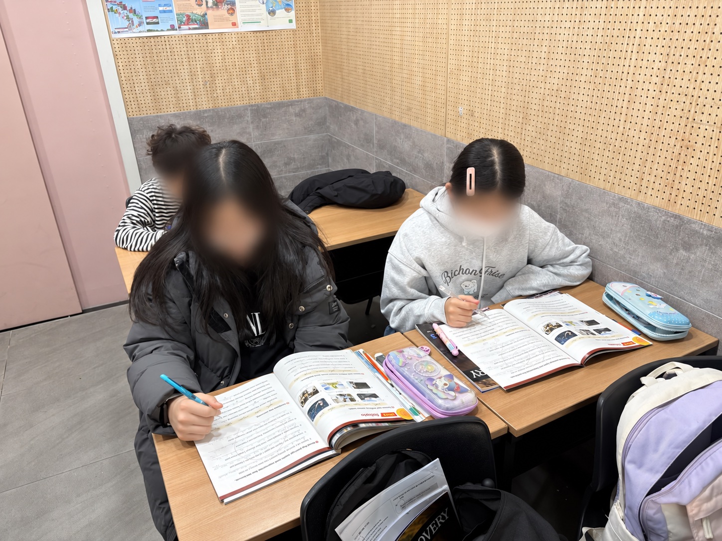 영어 교재를 읽고 직접 문장을 쓰는 학생들