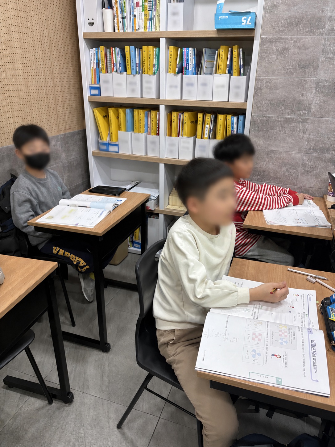 세 학생이 각자의 교재로 문제를 해결하고 있는 DD반 Deep Drill 수업