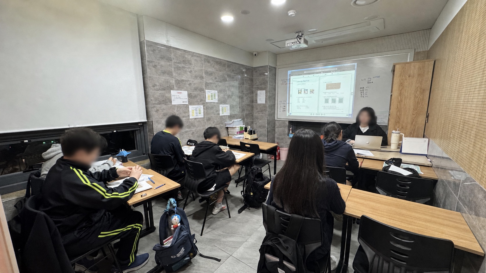 여러 학생이 함께 개념 설명을 듣고 각자 문제를 풀고 있는 DD반 그룹수업